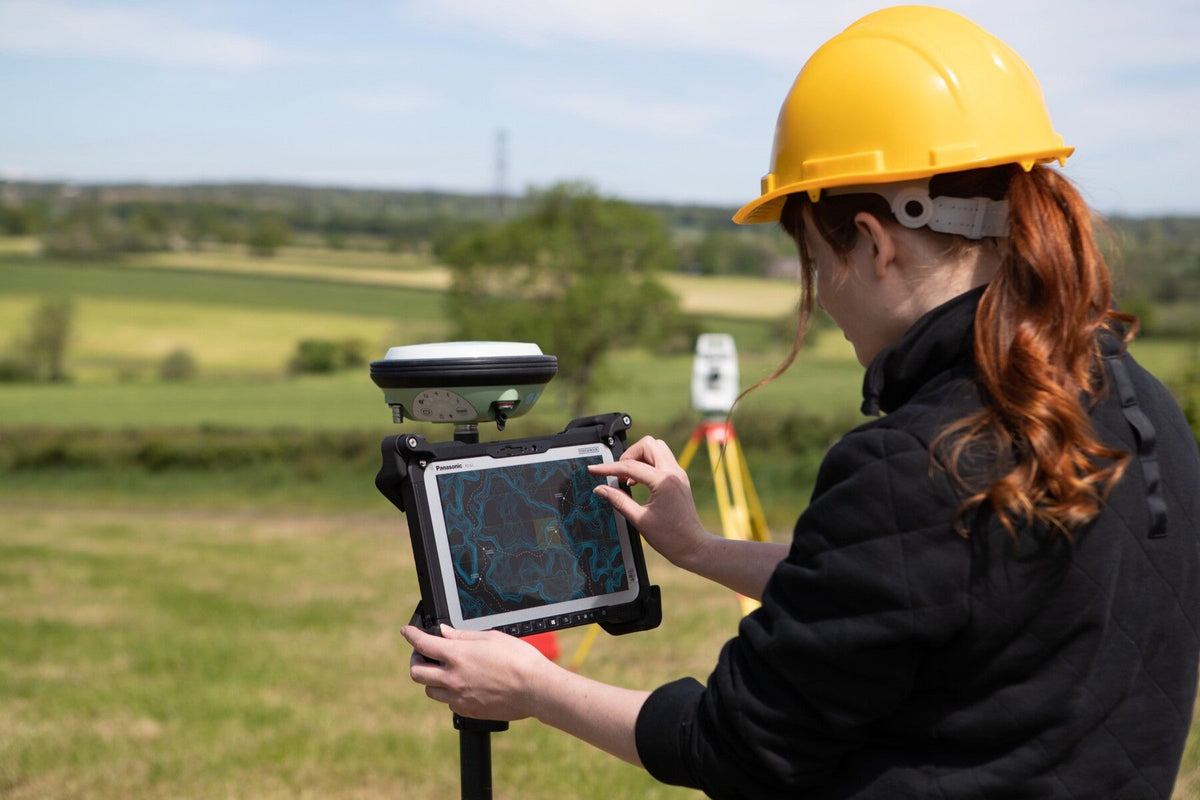 Surveyor using the Panasonic TOUGHBOOK G2 mk3 (Wi-Fi, micro-SD reader, fingerprint reader, Swiss plug) on a GNSS pole for field mapping and GIS data capture