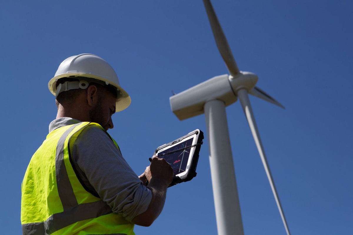 Wind farm engineer using the Panasonic TOUGHBOOK G2 mk3 (Wi-Fi, 2D barcode reader, EU plug) rugged tablet outdoors in direct sunlight
